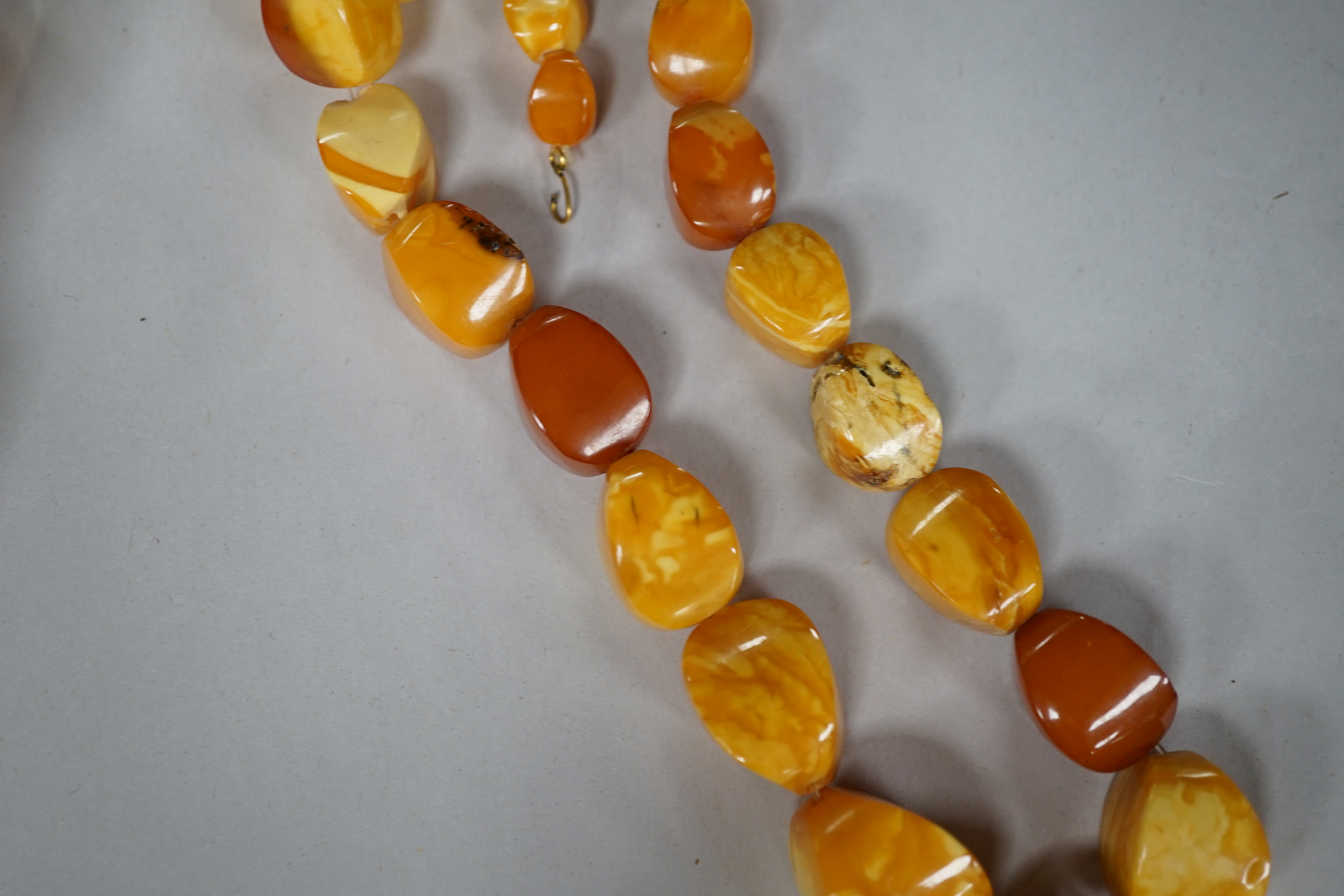 A single strand amber pebble bead necklace, 78cm, gross weight 93 grams. Condition - poor to fair